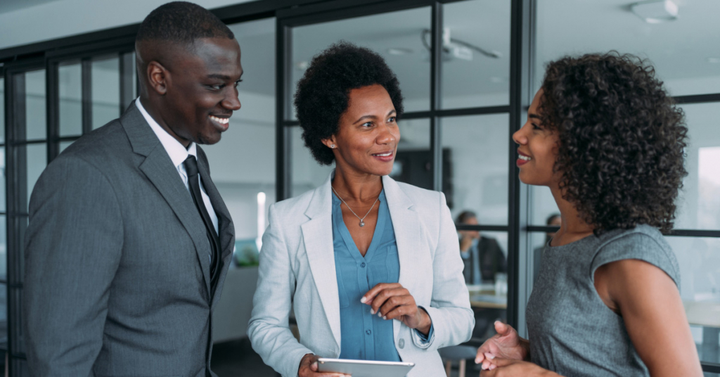 Three coworkers having a discussion in modern office