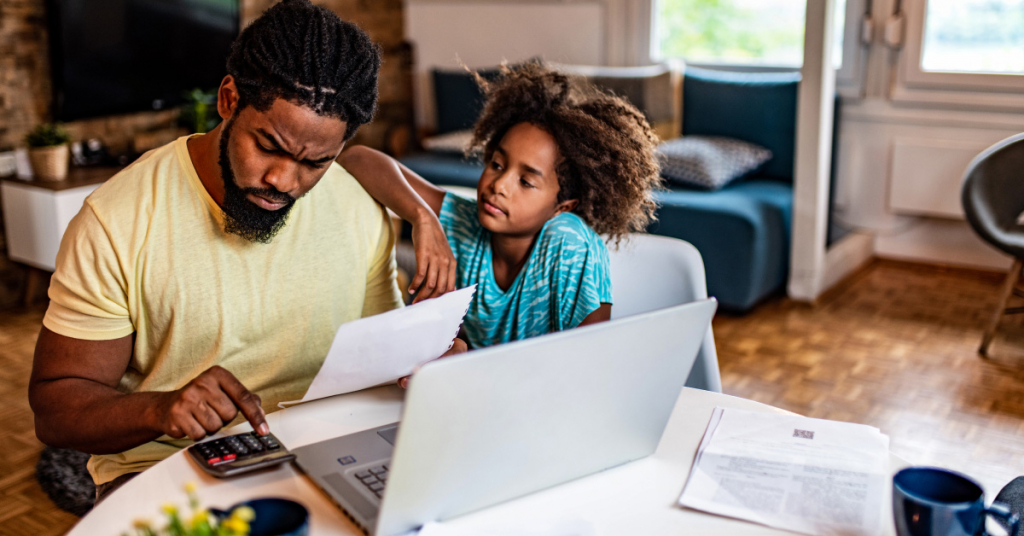 Frustrated African American man doing home finances with little daughter in the living room